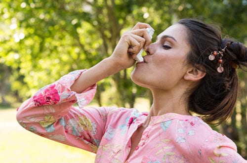 woman using inhaler asthma